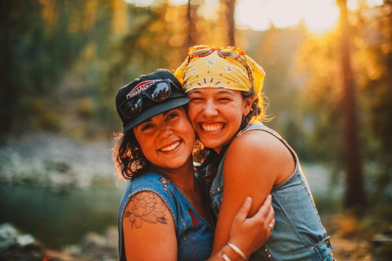 Two women pose and smile for the camera in the forest along the Main Salmon River in Idaho.