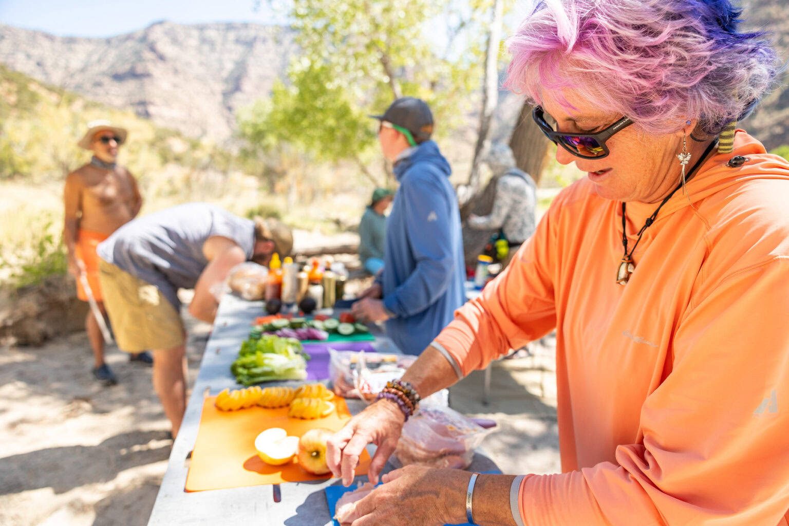Guides prepare lunch on a Desolation Canyon LGBTQ+ river trip.