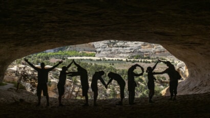 A group of people in a cavern use their bodies to form the word "Yampa" in celebration of the Yampa River