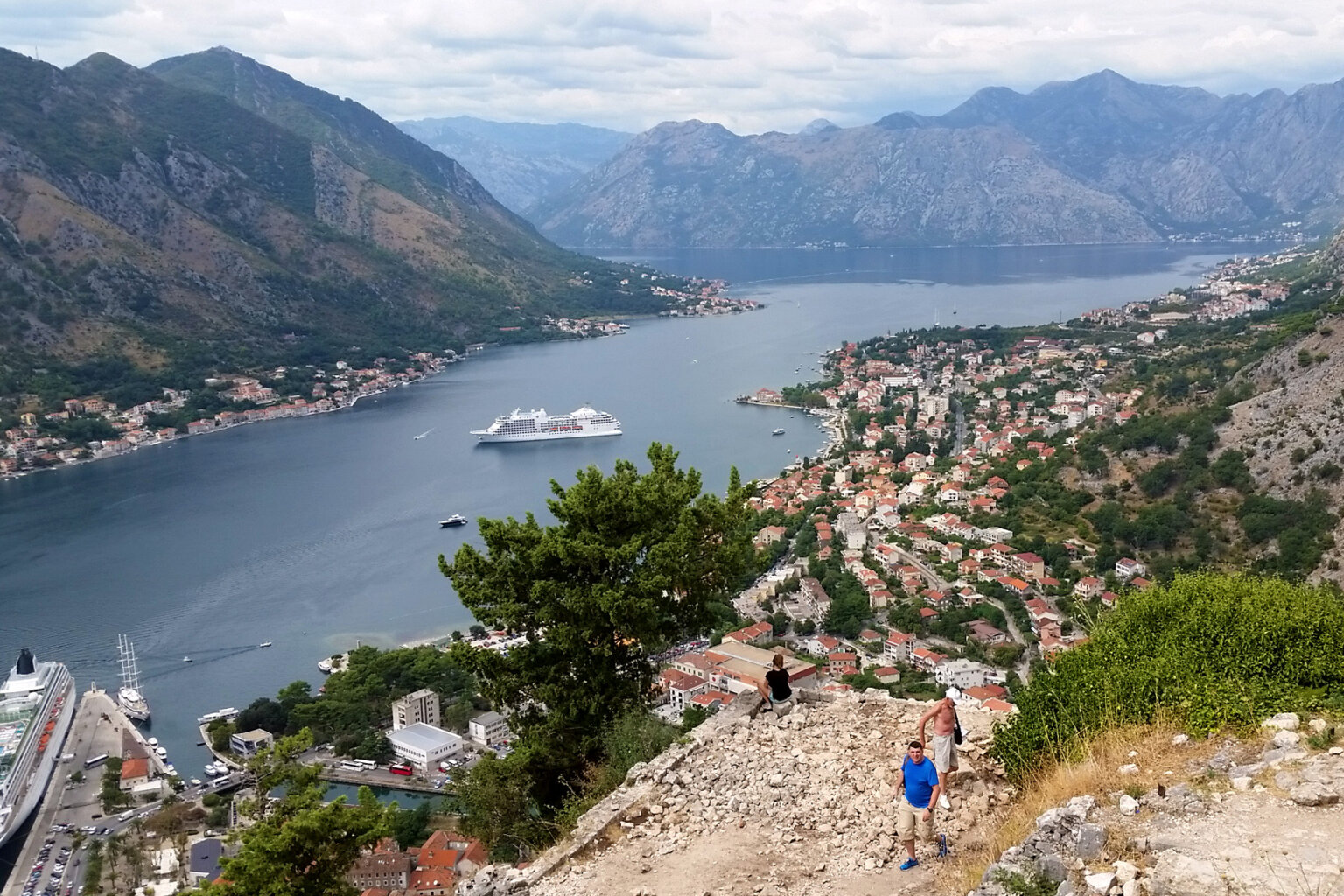 Guests hike high above a town overlooking the water in Croatia.