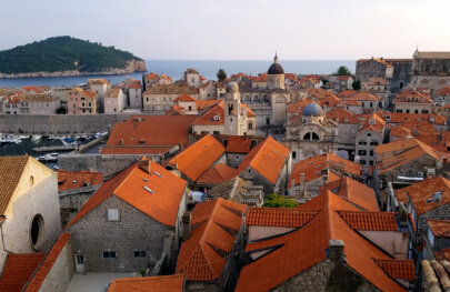 View from high above of historical architecture featuring orange roofs in a sea side town in Croatia.