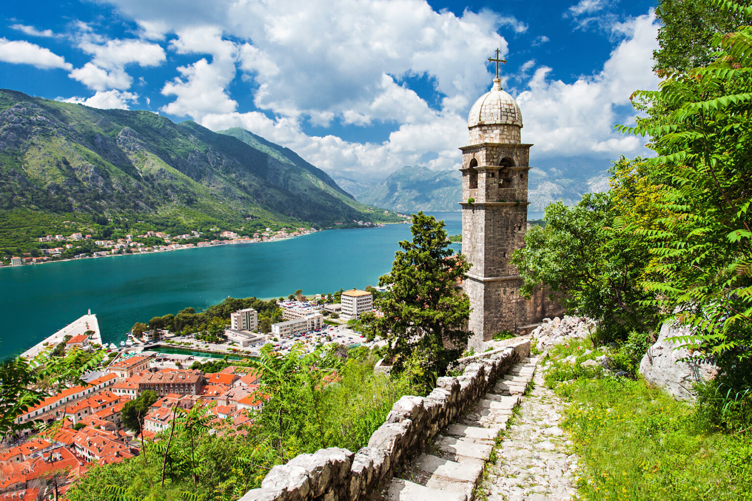 A historical town in Croatia from above surrounded by vibrant green vegetaion and a turquoise blue river.
