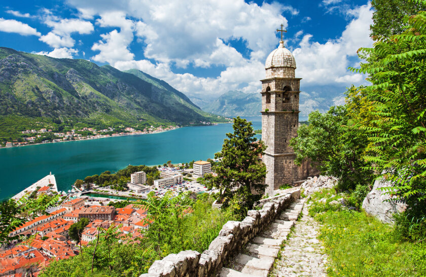 A historical town in Croatia from above surrounded by vibrant green vegetaion and a turquoise blue river.