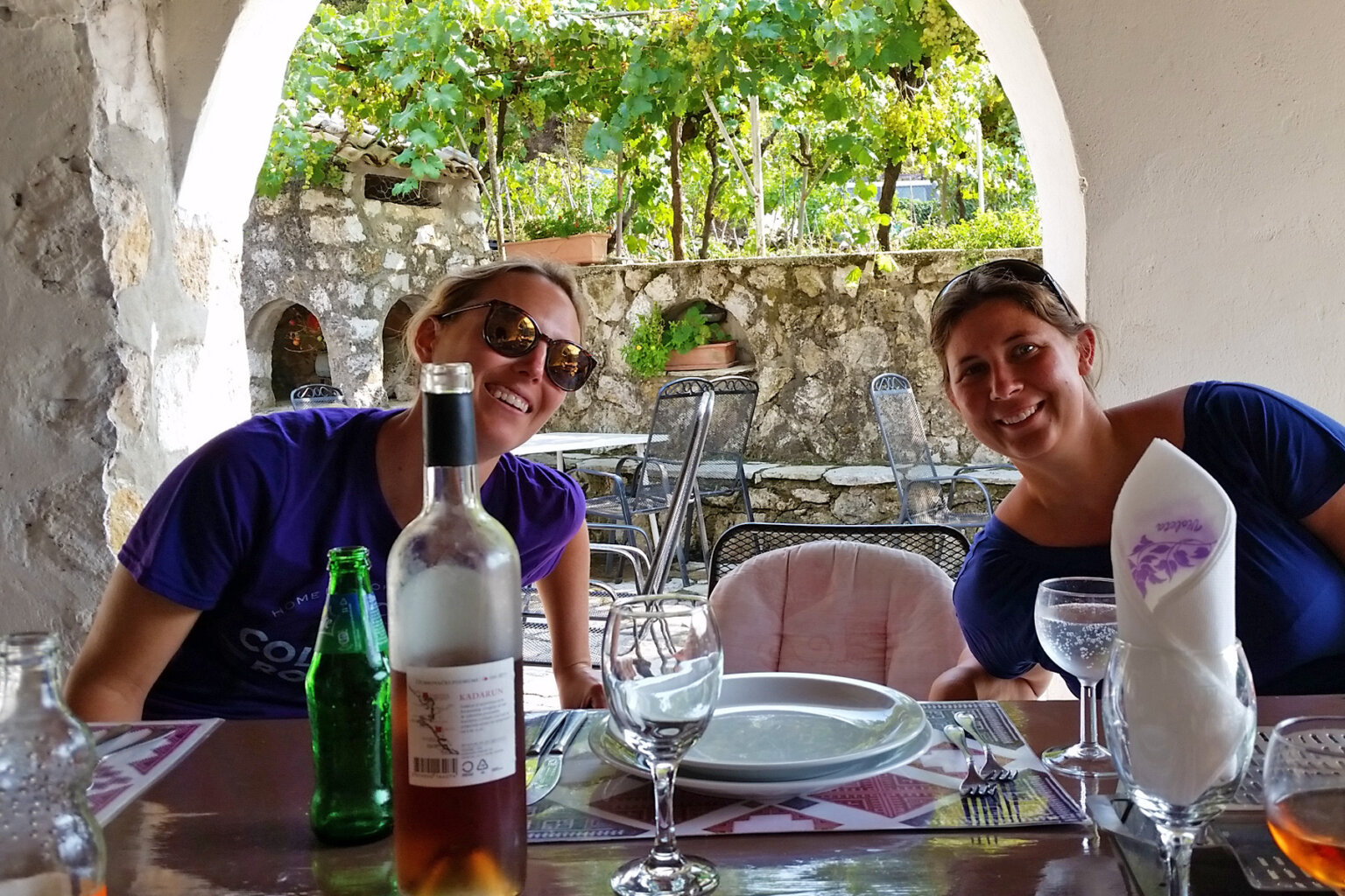Two guests smille and pose for the camera while dining at a restaurant in Croatia.