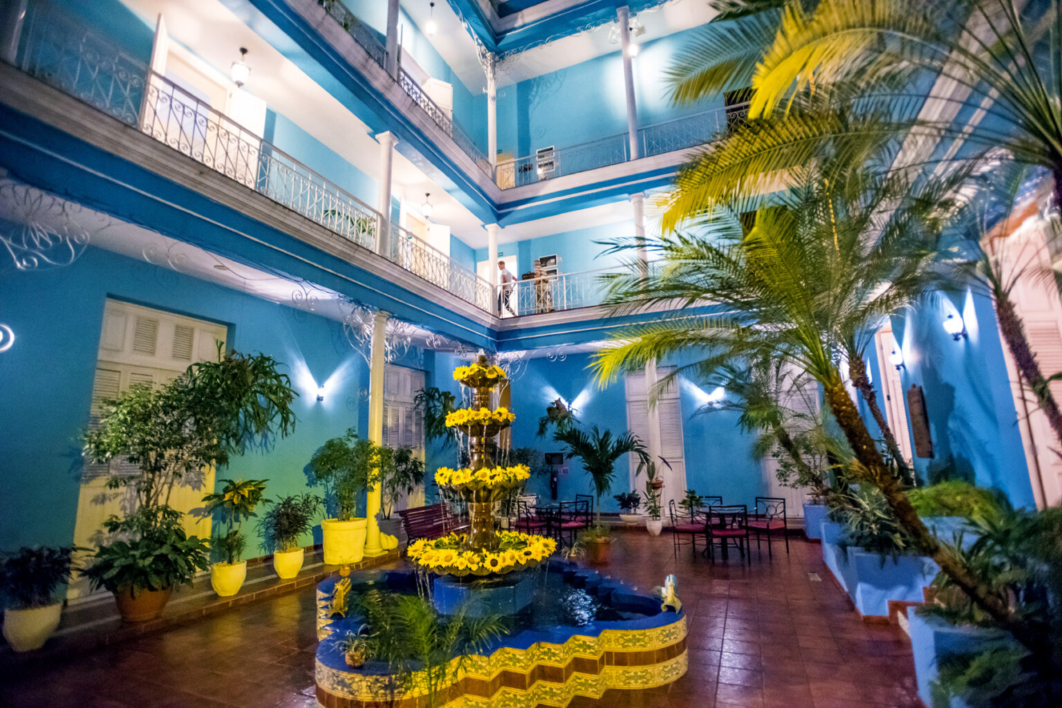 A festive courtyard in the middle of a vibrant blue hotel in Cuba.