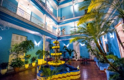 A festive courtyard in the middle of a vibrant blue hotel in Cuba.