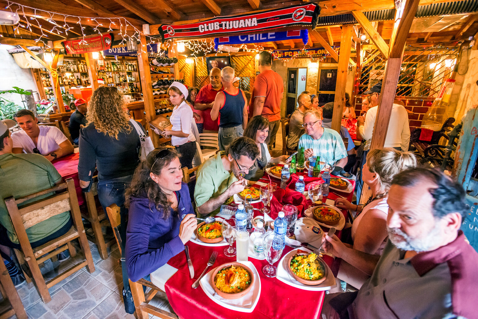 A vibrant restaurant is packed with happy people enjoying authentic Cuban fare.