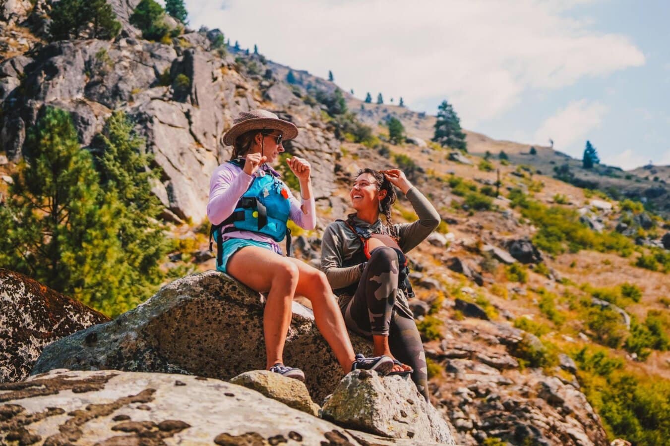 Two women sit on a rock on a side hike while on a Main Salmon River rafting trip in Idaho.