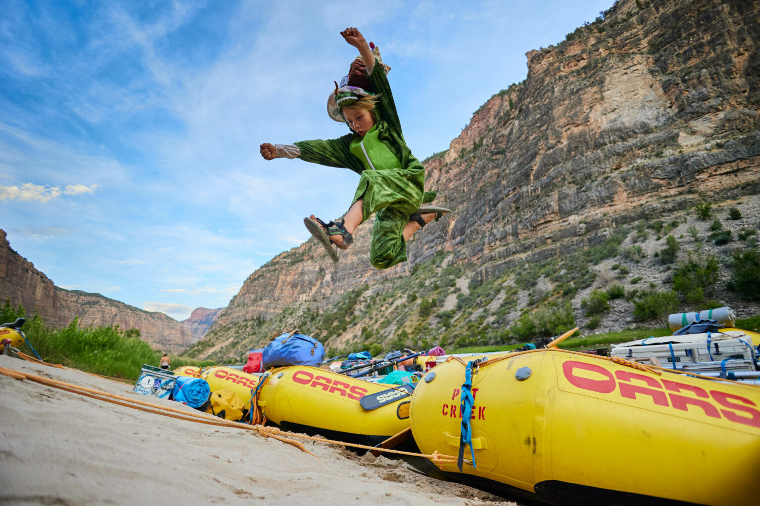 Kid jumping off a raft onto the river bank on the Green River through Gates of Lodore.