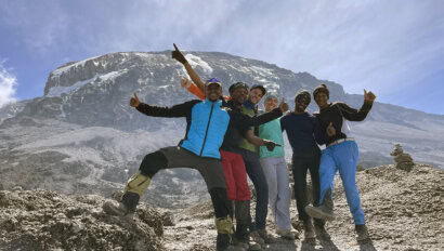 A group celebrates as they approach the summit of Mount Kilimanjaro