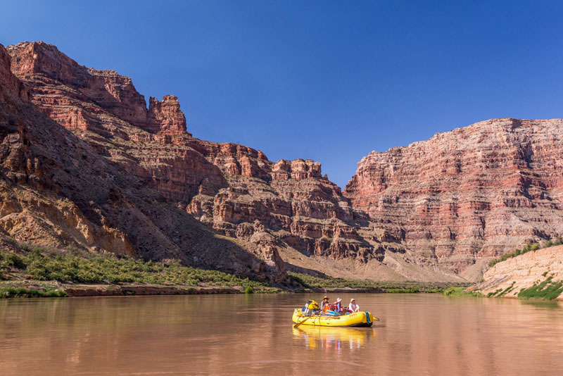 A yellow raft floats on the Colorado River in Cataract Canyon.
