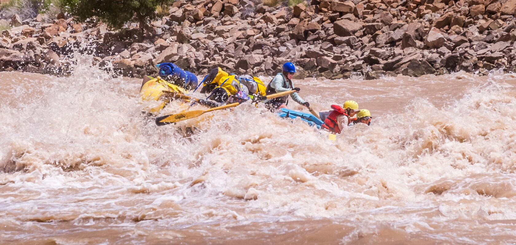 An OARS guide rows a raft through whitewater in Cataract Canyon in Utah