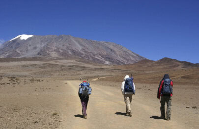 A group of hikers set out on a barren trail that leads to the summit of Mount Kilimanjaro