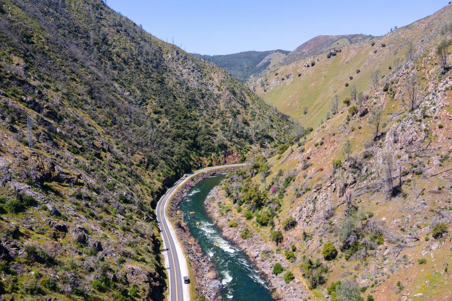 A drone shot of the Merced River canyon with OARS rafts on the river