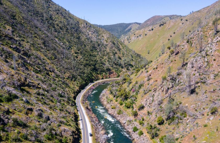 A drone shot of the Merced River canyon with OARS rafts on the river