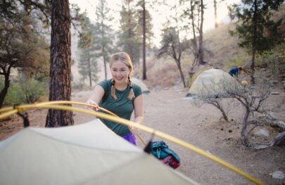 A girl sets up a tent on a rafting trip on the Middle Fork of the Salmon River in Idaho