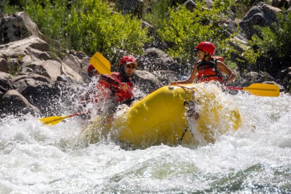 A raft with OARS guide school participants splashes through a rapid on the South Fork of the American River