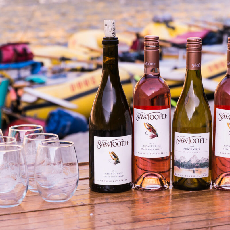 Wine bottles lined up on a table on the Main Salmon River bank.