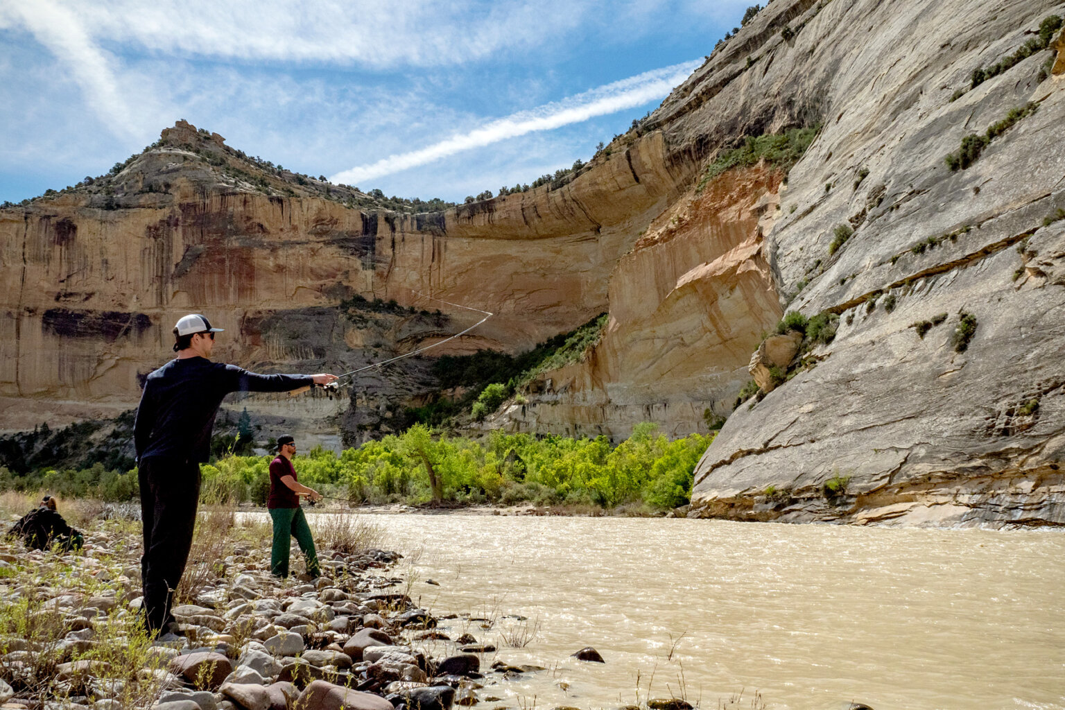 Two men fish along the shoreline on the Yampa River.