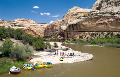 View from above of guides preparing lunch while guests relax on the beach along the Yampa River.